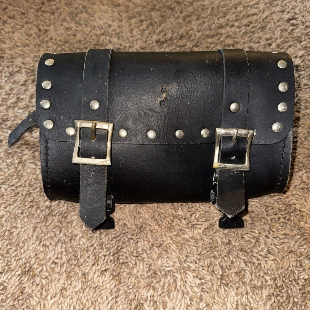 Black leather motorcycle tool bag with silver studs.
